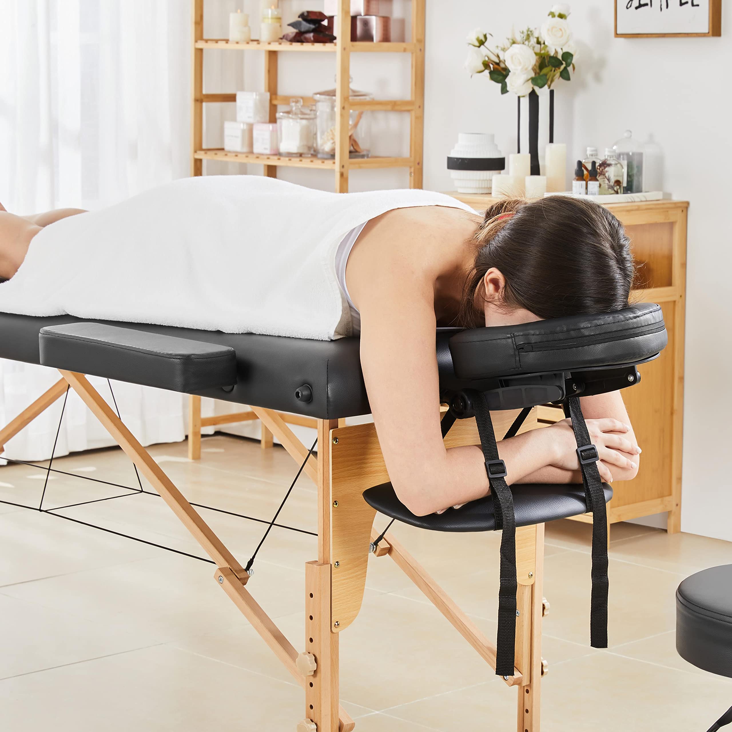 Professional lash artist table massage bed with wooden legs and black cushioning for comfortable treatments