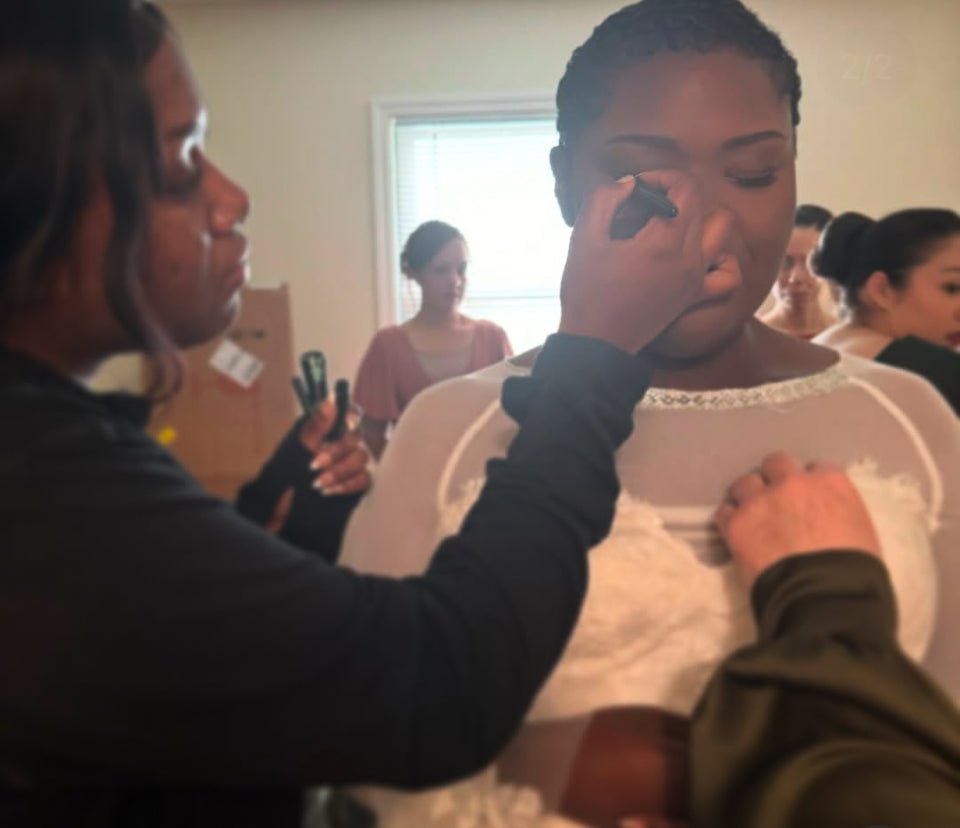 Vela Lash Bar artist applying makeup on bride for wedding makeup services in a bright room
